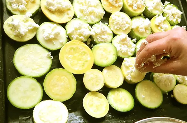 Zucchini mit Feta auf Backblech für Backofen streuseln